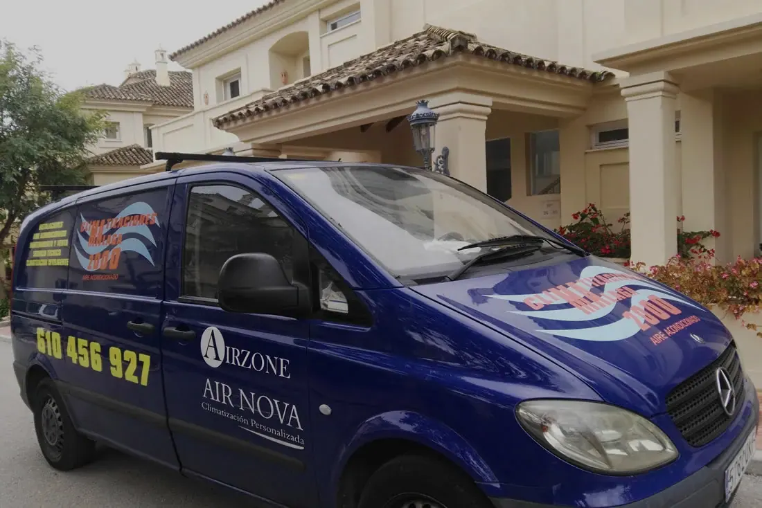 Furgoneta de Climatizaciones Málaga 2000 aparcada frente a una vivienda