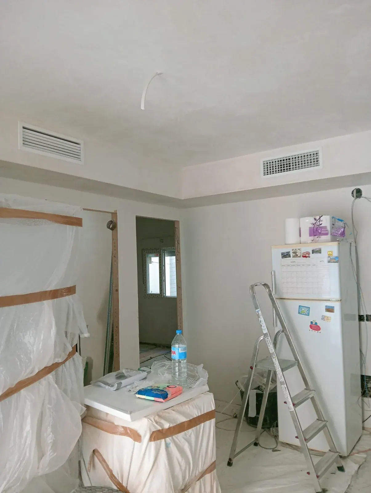 Rejillas de impulsión y de retorno instaladas en el falso techo de una vivienda durante la obra