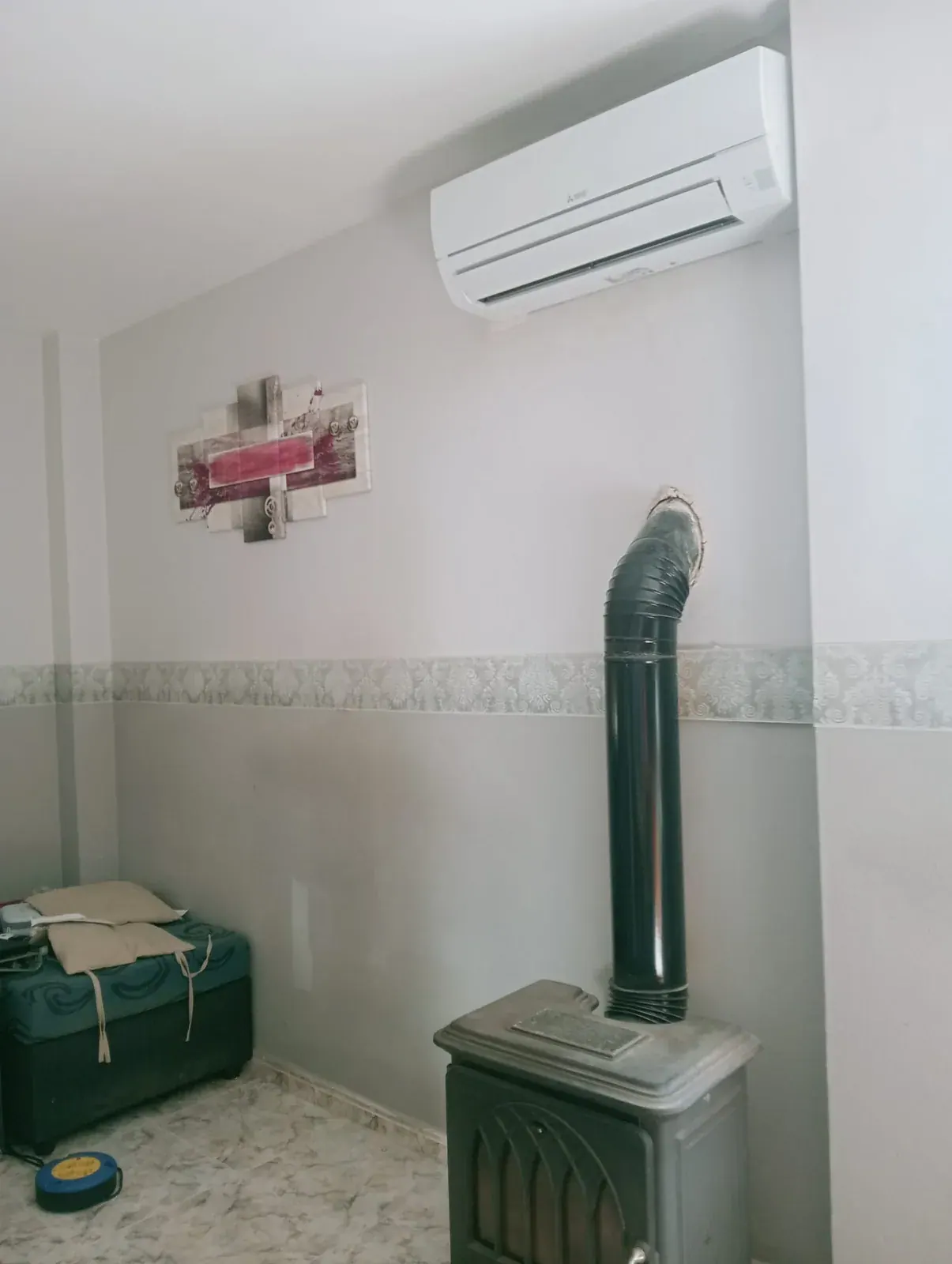 Unidad interior de aire acondicionado split instalada en el salón de una vivienda
