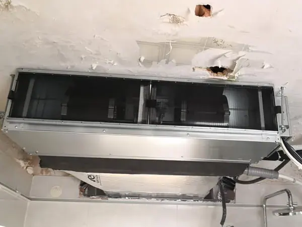 Unidad interior de conductos colgada en el falso techo antes de cerrarlo